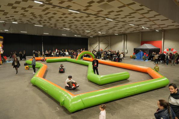 Vue d'un espace événementiel avec un circuit gonflable et des participants