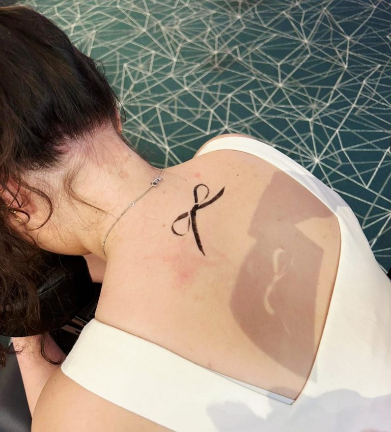 Tatouage à l'encre noire en forme de boucle sur le dos d'une personne