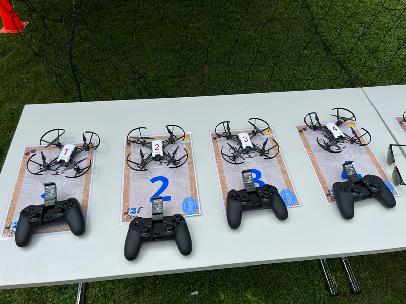 Table avec des drones et des manettes de jeu lors d'un événement.