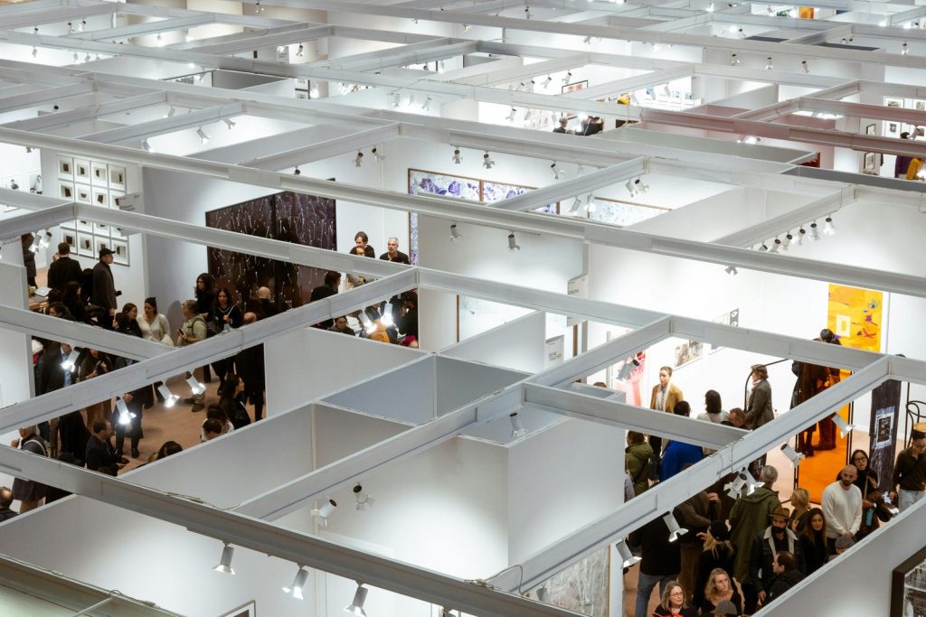 Vue aérienne d'un salon professionnel avec de nombreux visiteurs circulant entre les stands — animation stand Universel Events PACA